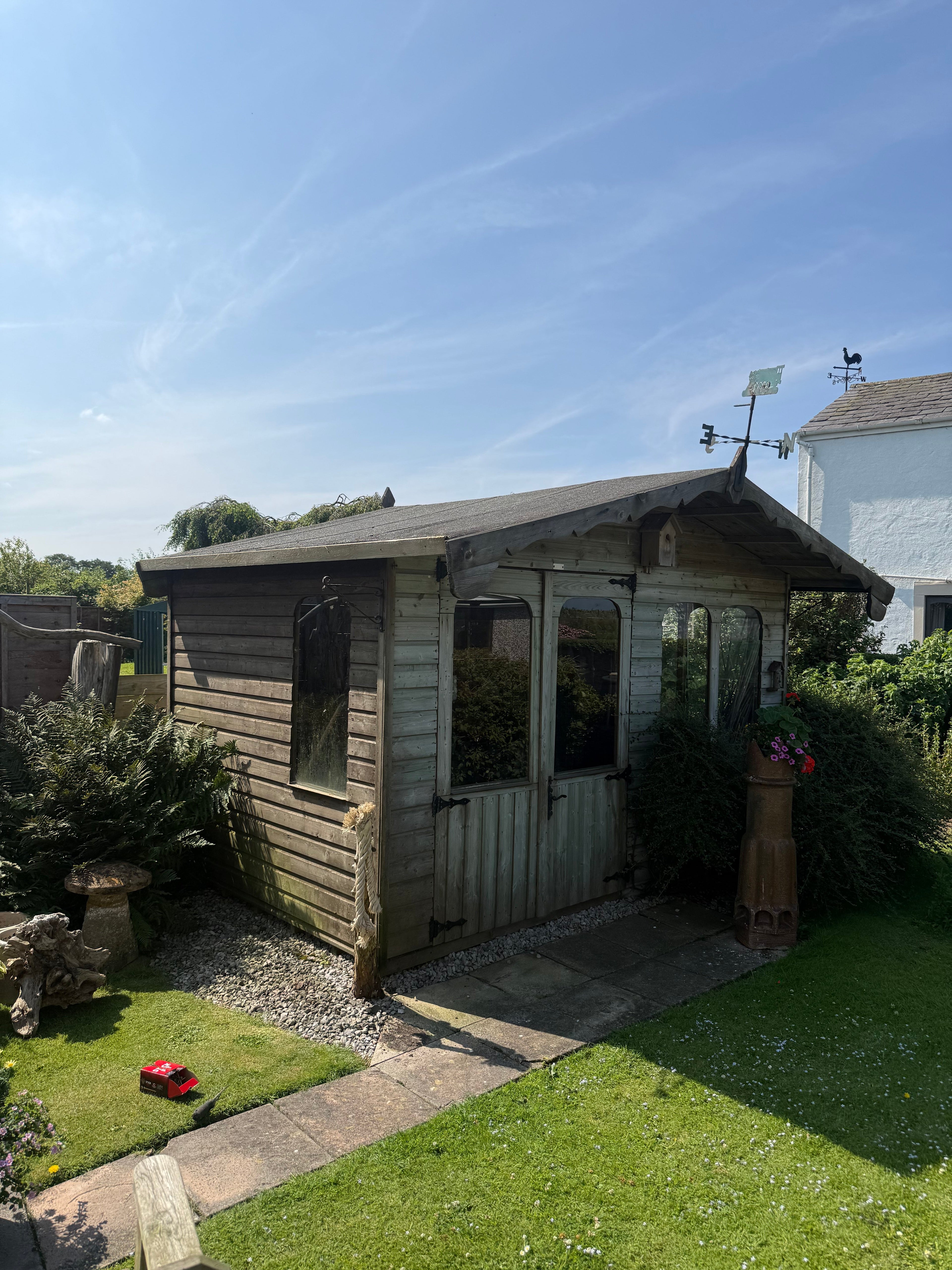 Weathered log cabin in Cockerham Lancashire with sagging roof overhang and rotten timber prior to repair by Bespoke Oak and Slate